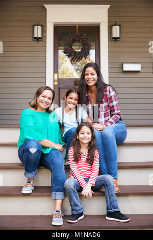 Federleiste Generation Familie Sitzen auf Schritte vor dem Haus Stockfoto