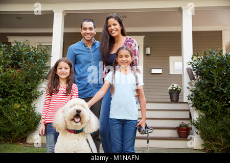 Porträt der Familie, die Vor dem Haus mit Hund Stockfoto