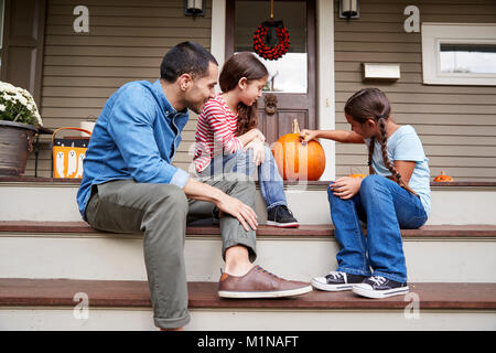 Vater und Tochter Zeichnung Gesicht auf Halloween Kürbis Stockfoto