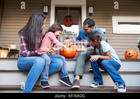 Familie schnitzen Halloween Kürbis auf Haus Schritte Stockfoto