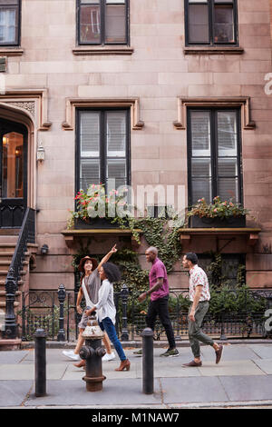 Eine Gruppe von Freunden zu Fuß entlang Urban Street in New York City Stockfoto