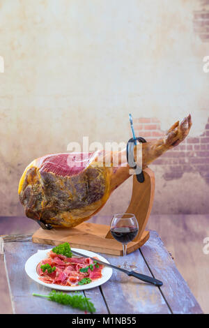 Jamon. Jamon Serrano. Traditionelle spanische Trocken spanische Schweinefleisch Schinken auf einem Teller mit Messer auf alten Vintage Holz- Hintergrund ausgehärtet Stockfoto