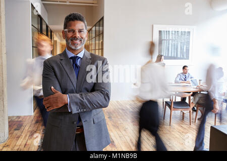 Portrait von im mittleren Alter schwarzer Mann in einem geschäftigen modernen Arbeitsplatz Stockfoto