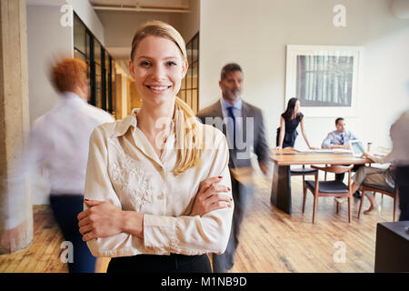 Portrait der junge blonde Frau in einem geschäftigen modernen Arbeitsplatz Stockfoto