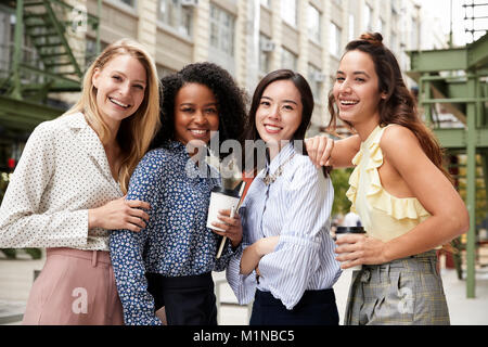 Vier weibliche Mitarbeiter lächelnd in die Kamera außerhalb Stockfoto