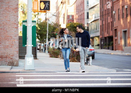 Junge Hispanic Paar gehen Hand in Hand in Brooklyn Straße Stockfoto