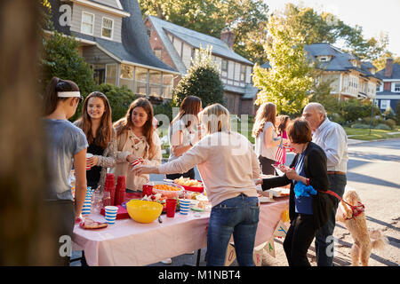 Nachbarn sprechen, um einen Tisch in einem Block Party Stockfoto