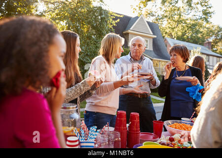 Nachbarn sprechen und Essen in einem Block Party, in der Nähe Stockfoto