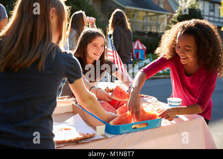 Mädchen, die sich Wassermelone zu einem Block Party Stockfoto