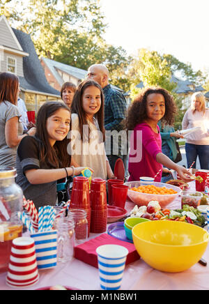 Vor - jugendlich Mädchen lächelnd in die Kamera zu einem Block Party in der Tabelle Stockfoto