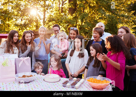 Junge Mädchen bläst die Kerzen an ihrem Geburtstag Gartenparty Stockfoto