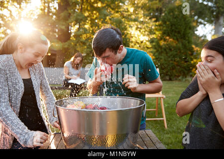 Freunde Teenager apple bobbing Garden Party Stockfoto