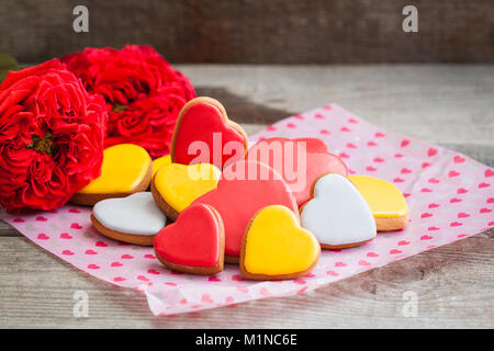 Lebkuchen cookie Herzen mit Garten Rosen über die hölzerne Hintergrund. Getönt. Stockfoto
