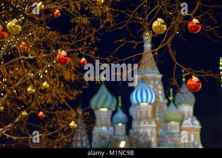 Baum dekoriert mit festlichen Bälle gegen Kathedrale im Hintergrund St. Basil's im Zentrum von Moskau während der Weihnachtszeit während der Nacht. Stockfoto