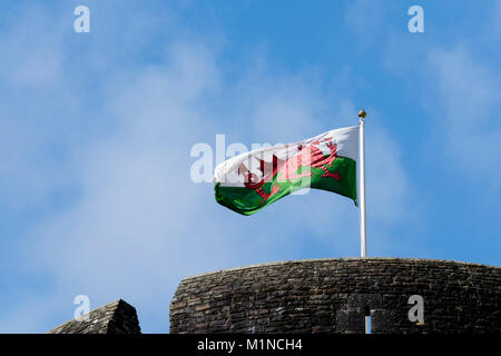 Walisische Flagge über Caerphilly Castle, auf Fahnenmast, der im Wind weht Stockfoto