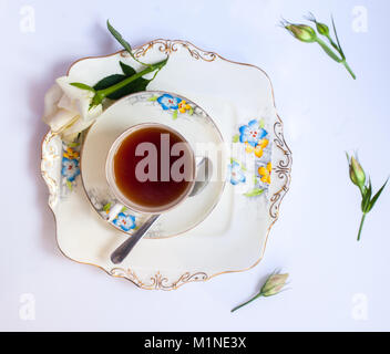 Flatlay mit eleganten Teeservice surrounde von Blumen Stockfoto