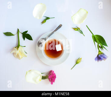 Flatlay mit eleganten Teeservice surrounde von Blumen Stockfoto