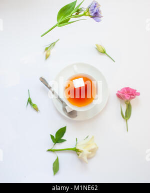 Flatlay mit eleganten Teeservice surrounde von Blumen Stockfoto