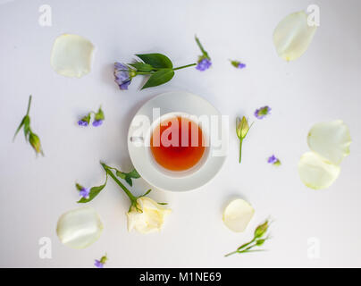 Flatlay mit eleganten Teeservice surrounde von Blumen Stockfoto