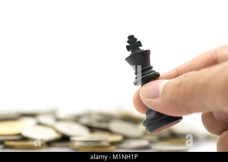 Geschäftsmann mit einem König Schach ist auf einem Haufen Münzen platziert. Verwendung als Hintergrund Business Konzept und Strategie konzept mit Platz für Ihren Text kopieren Stockfoto