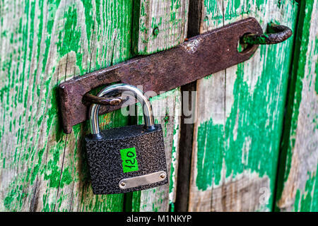 Ein neues Schloss mit einem Store Tag auf einem alten ländlichen Scheune in der Nähe auflegt. Stockfoto