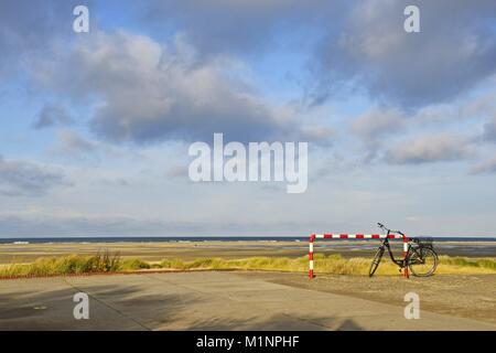 Ein schwarzes Fahrrad stehend an einer roten und weißen Bar vor der großen Marine auf der Insel Borkum, 19. November 2016 | Verwendung weltweit Stockfoto