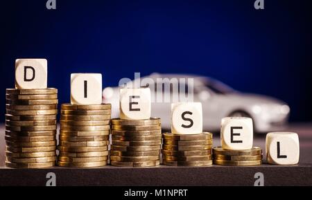 Stapel von Münzen und das Wort diesel mit einem Auto im Hintergrund | Verwendung weltweit Stockfoto