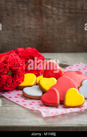 Lebkuchen cookie Herzen mit Garten Rosen über die hölzerne Hintergrund. Getönt. Stockfoto