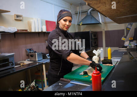 Mädchen Sushi Chef bereitet Essen in der Küche im Restaurant Stockfoto