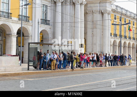 Eine lange Schlange von Menschen auf die Ankunft der elektrischen Straßenbahn, Lissabon, Portugal Stockfoto