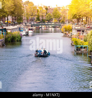 Freunde um mit dem Boot entlang der Grachten von Amsterdam, Holland Stockfoto