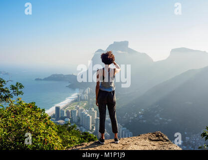 Brasilianischen Mädchens gegen Pedra da Gavea und Sao Conrado von Dois Irmaos Berg, Rio de Janeiro, Brasilien, Südamerika Stockfoto