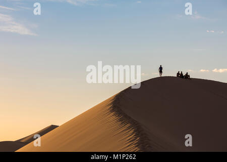 Menschen in Silhouette auf Khongor Sanddünen in der Wüste Gobi Gurvan Saikhan Nationalpark, Sevrei Bezirk, Provinz im Süden der Wüste Gobi, Mongolei, Zentralasien, Asien Stockfoto