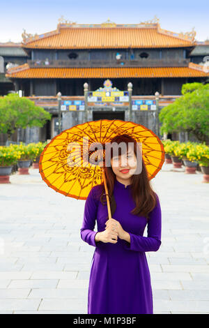 Frau in einem traditionellen Ao Dai Kleid mit einem Papier Sonnenschirm in der Verbotenen purpurnen Stadt Hue, UNESCO, Thua Thien Hue, Vietnam, Indochina, Asien Stockfoto