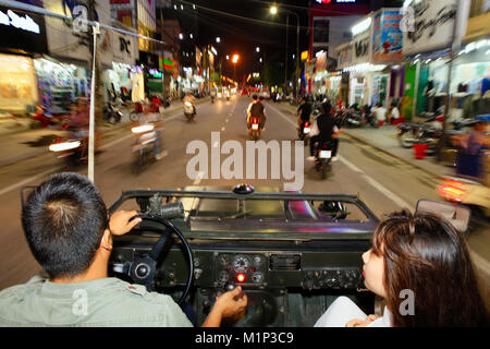 Ein vietnamesisches Paar in einem offenen Jeep fahren durch die Straßen von Hue, Vietnam, Indochina, Südostasien, Asien Stockfoto