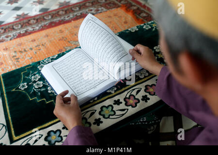 Muslimischen mann Lesen eines arabischen Heiligen Quran (Koran), Saigon Central Mosque, Ho Chi Minh City, Vietnam, Indochina, Südostasien, Asien Stockfoto