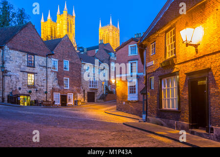 Blick auf den beleuchteten Kathedrale von Lincoln gesehen von den gepflasterten steilen Hügel in der Dämmerung, Lincoln, Lincolnshire, England, Vereinigtes Königreich, Europa Stockfoto