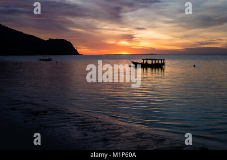 Magischen Sonnenuntergang mit traditionellen Boot an einem einsamen Strand in der Nähe von Surf spot scar Reef auf Sumbawa, Indonesien Stockfoto