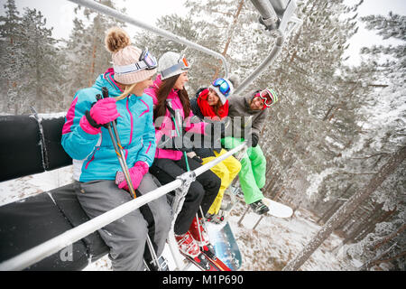 Gruppe von lächelnden Freunde Skifahrer bei Ski Sessellift im schönen, sonnigen Tag. Konzept der Ski Stockfoto