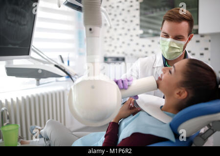 Junge Zahnarzt überprüfung oben Zähne Frau mit x-ray Stockfoto