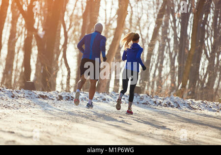 Die jungen Läufer Paar läuft durch den Wald, Rückansicht Stockfoto