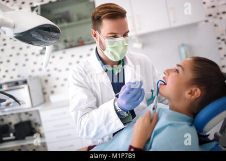 Männliche Zahnarzt Reparatur von Mädchen am Zahn Klinik Stockfoto