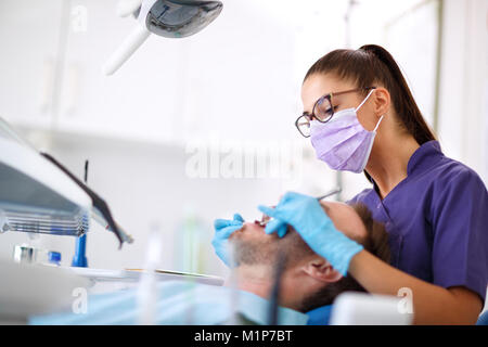 Junge weibliche Zahnarzt Reparatur Zahn des Patienten in der Klinik Stockfoto