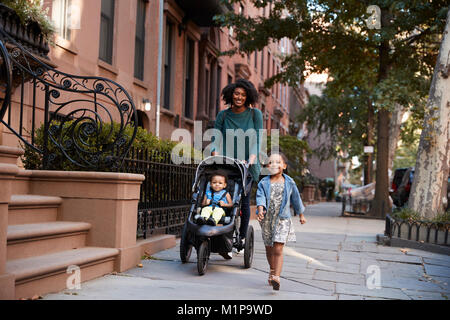 Mutter und zwei Töchtern bei einem Spaziergang die Straße runter Stockfoto