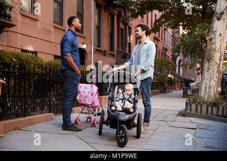 Zwei Vater Freunde mit zwei Kindern reden auf der Straße Stockfoto