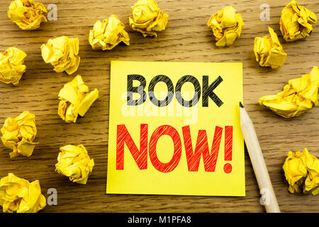 Wort, Schrift, Buchen Sie jetzt. Business Konzept für Buchung Buchung auf haftnotiz Papier auf Holz- Hintergrund geschrieben. Gefaltete gelbe Papiere auf den hinterg Stockfoto
