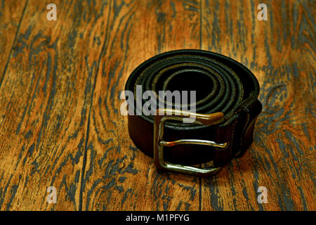Herren Leder Gürtel Sport Style und Herren Krawatte von Gucci und Holzboden Stockfoto