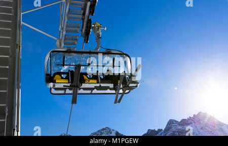 Skifahrer gehen Auf dem Sessellift gegen strahlend blauen Himmel - Ski Resort in Italien an sonnigen Wintertag Stockfoto