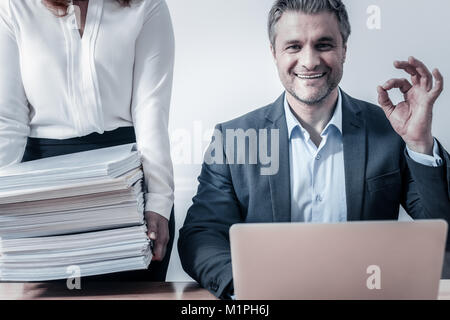 Mann lächelnd nach Überprüfung Stapel von Dokumenten aufgeregt Stockfoto