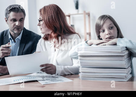 Das arme Mädchen warten auf ihre Eltern arbeitet im Büro Stockfoto